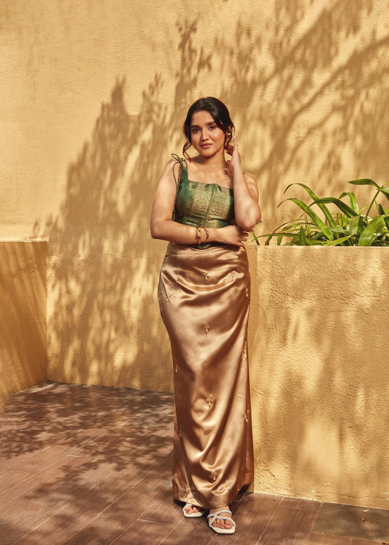 Anikha Surendran in green and gold satin in the warm courtyard light at The Westin Chennai