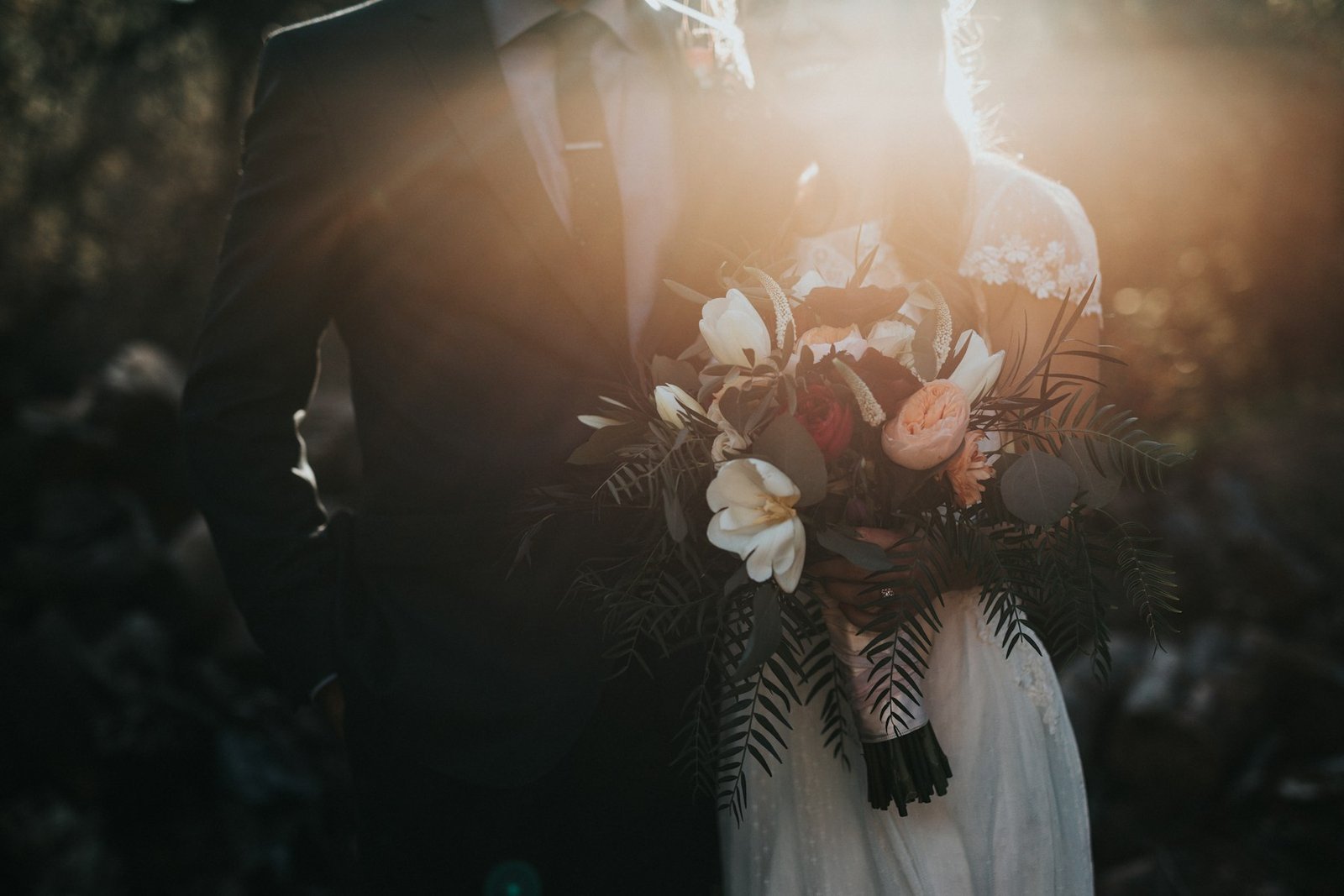 Bride and groom holding a bouquet together